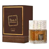 A perfume bottle with a brown liquid and a geometric pattern on the glass, next to its packaging box which has 'KHAMRAH QAHWA Lattafa' written on it.